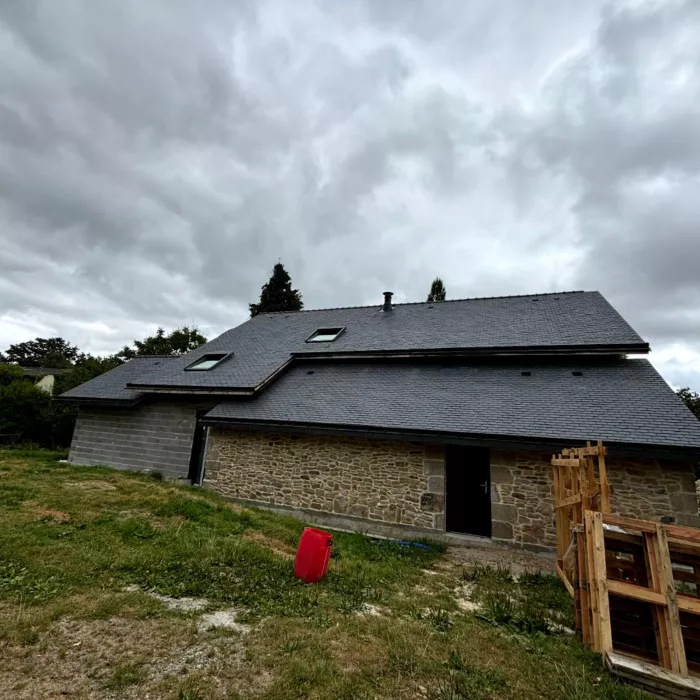 Maison en pierre avec toiture en ardoise rénovée, travaux de couverture réalisés par un couvreur